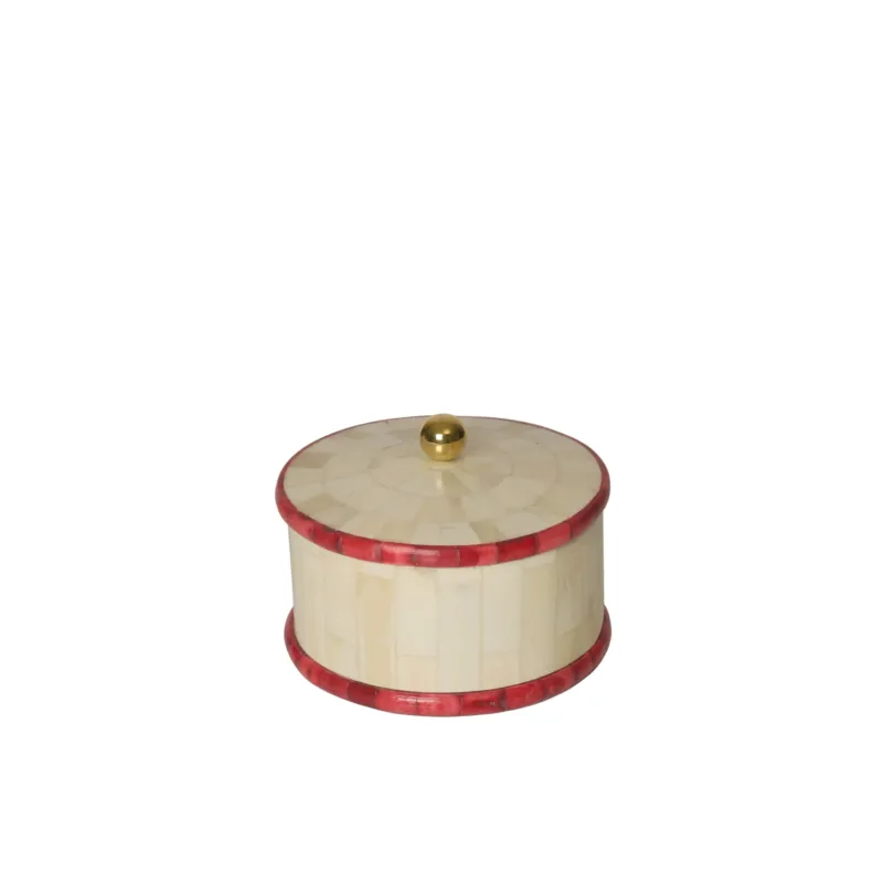 Round decorative box with red inlay and gold knob on a white background